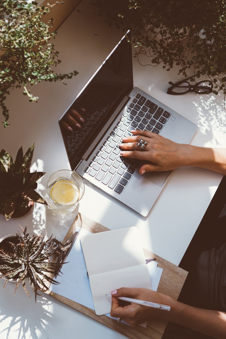 Woman Typing and Writing Simultaneously